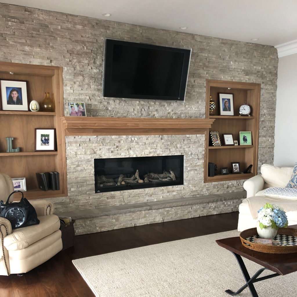 stacked stone fireplace, wood shelves< wood mantel, styling bookcases