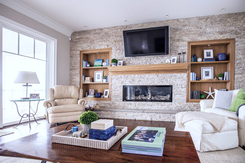 styling bookcases, stacked stone fireplace wall with wood shelves and built-in, and mantel 